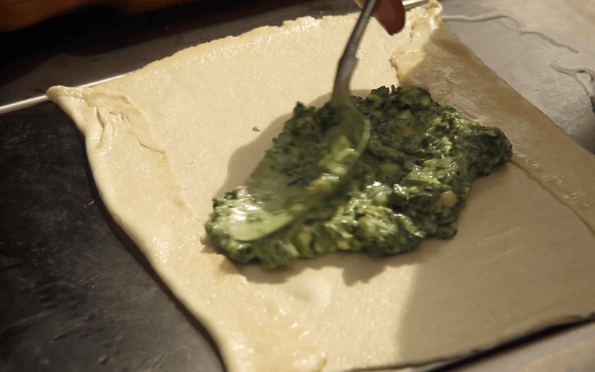 Roll out the dough balls on a greased surface, then fill with the spinach mixture